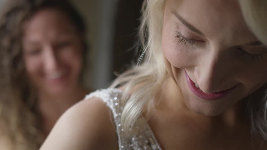 Two women smile as they try on formal gowns