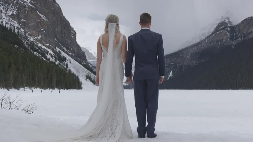 A groom standing in the middle of the snow