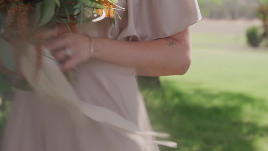 A woman holds a bouquet of flowers outside