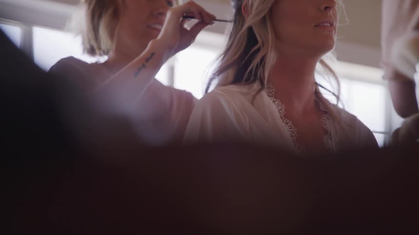 A woman teases the hair of another woman