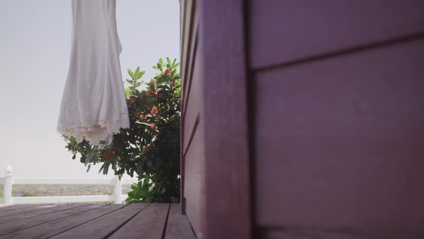 A wedding dress hangs outside