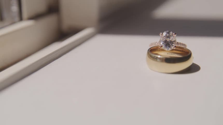 A diamond ring sits on a shelf in daylight