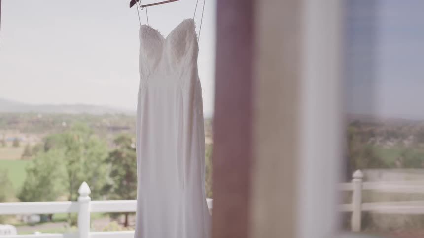 Wedding dress hanging with view of landscape in background