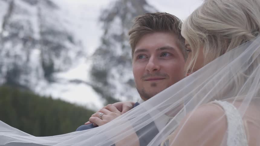 Groom and bride cuddle each other and the bride looks at the groom during the ceremony