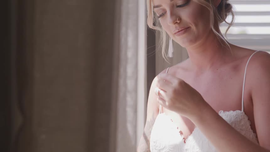 Girl in wedding dress putting in earring