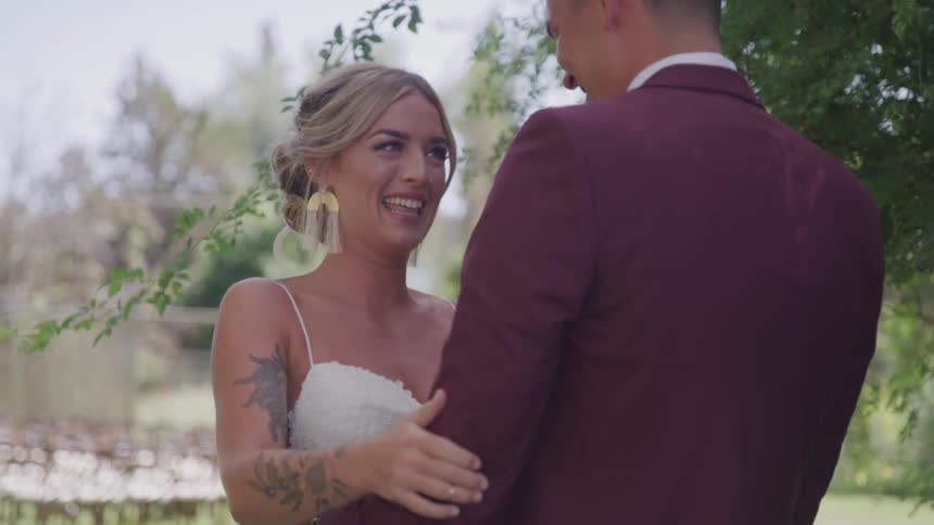 Groom and bride cuddle and look at each other during the wedding ceremony