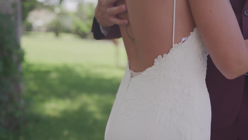 Groom touches the brides back during the wedding ceremony