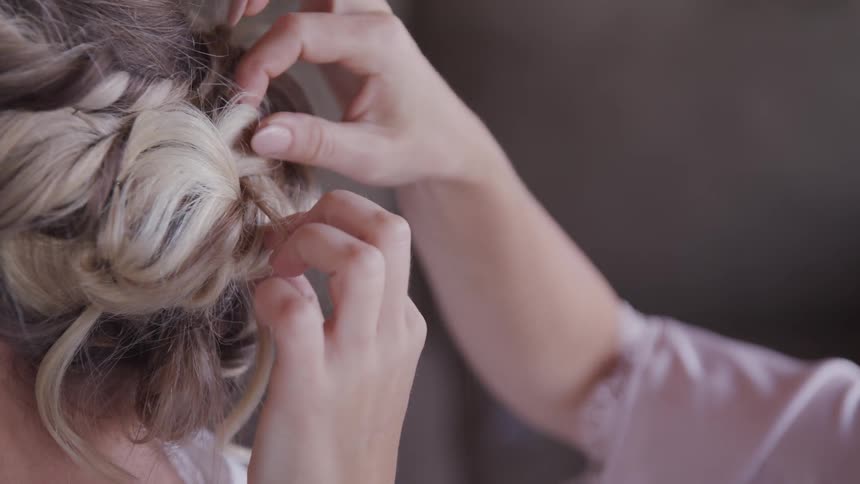 A woman fixes another womans hair