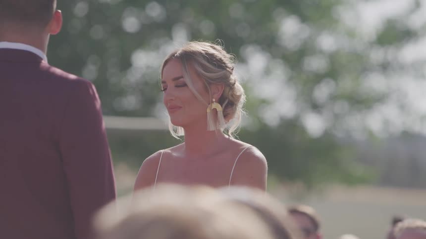 A bride looks to her groom standing in front of her