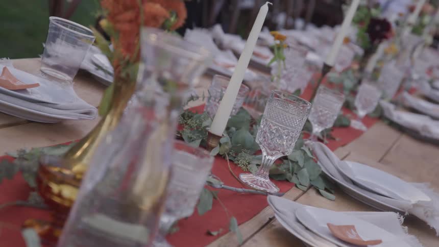 A long table full of decorations glasses and plates