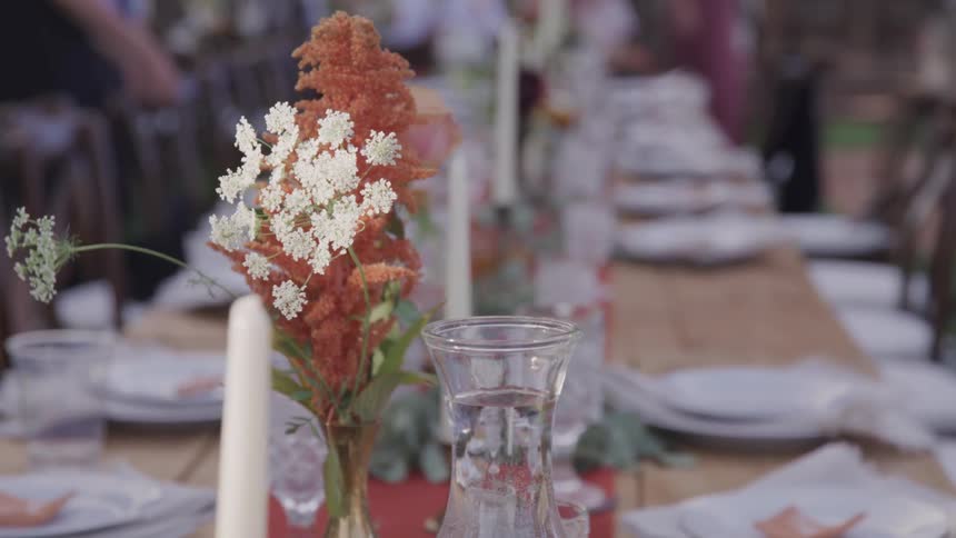 A small flower centerpiece sits on a large dining table