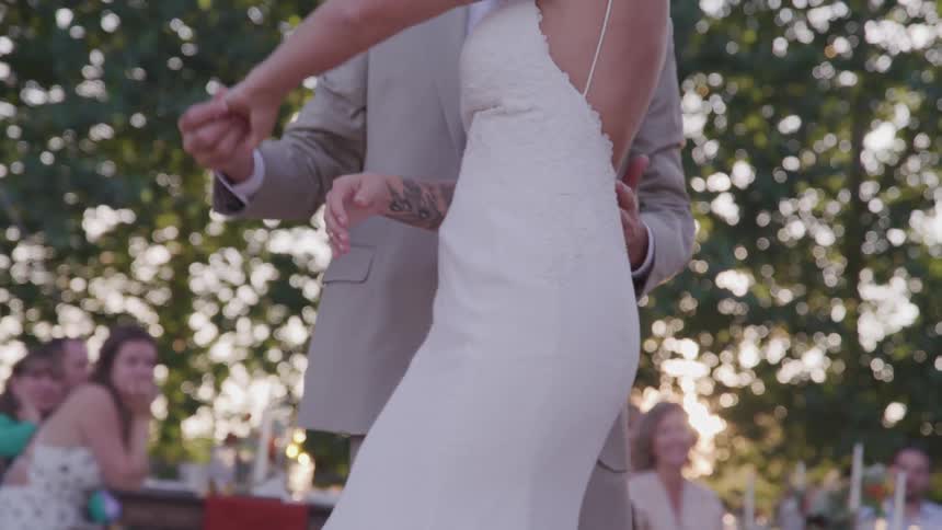 Woman in wedding dress dances with a man in a suit