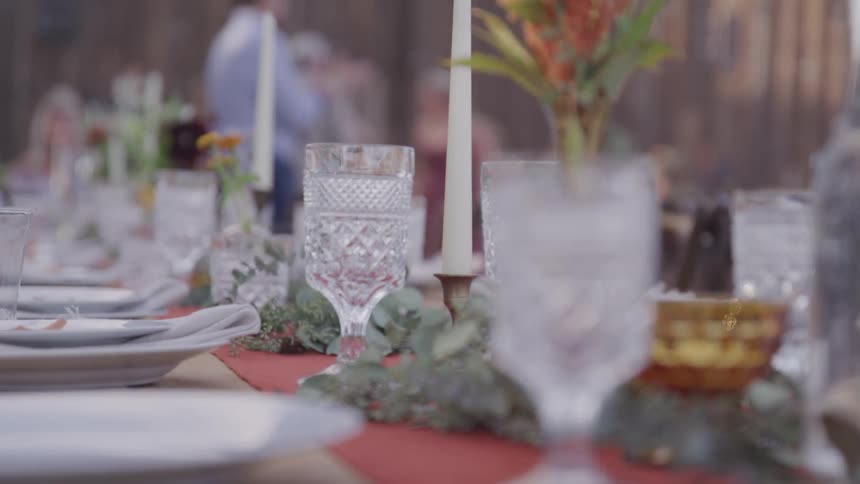 A table is set and people walk about