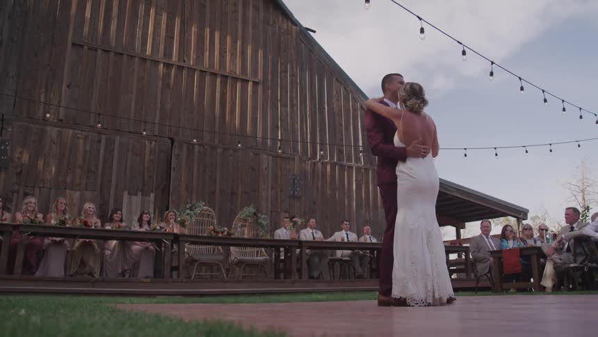 A bride and groom dance in front of people