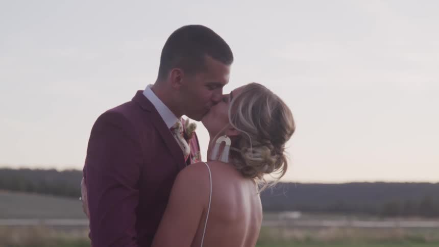 Bride and groom hold and kiss each other during wedding ceremony