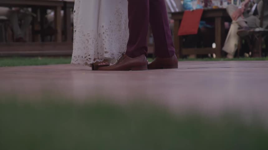 A man and woman slow dance in front of a crowd