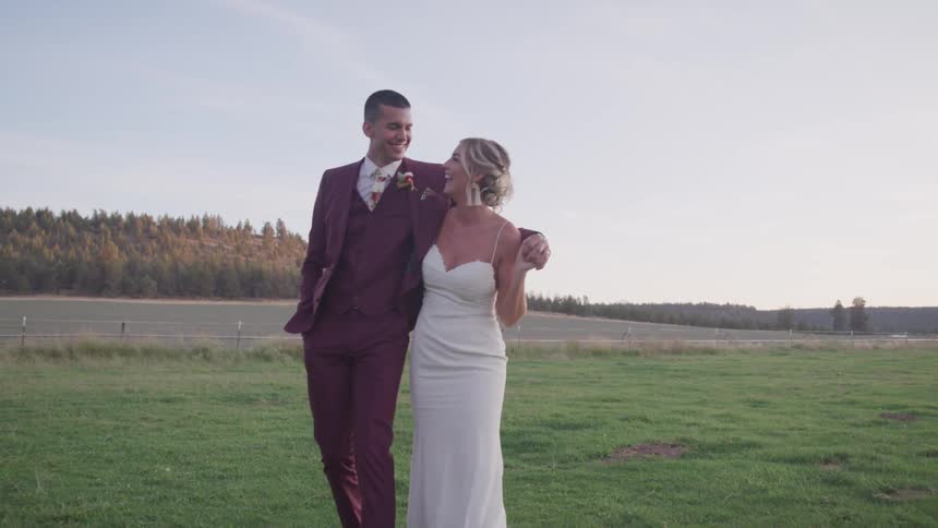 A man and woman walk together in the grass