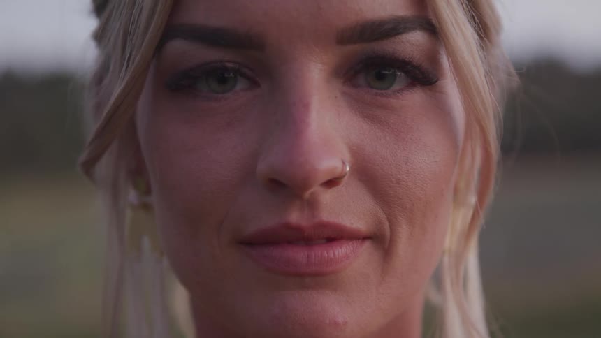 Close up of a blonde woman looking straight at the camera