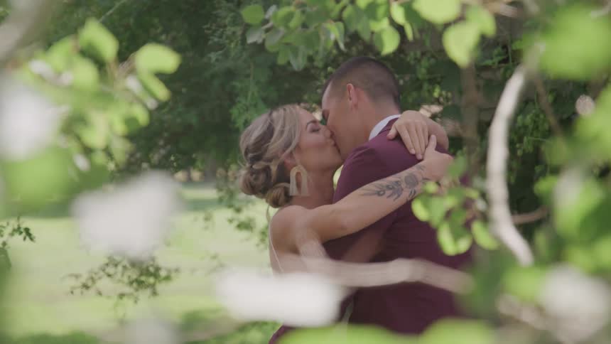 Bride and groom hugging in the park
