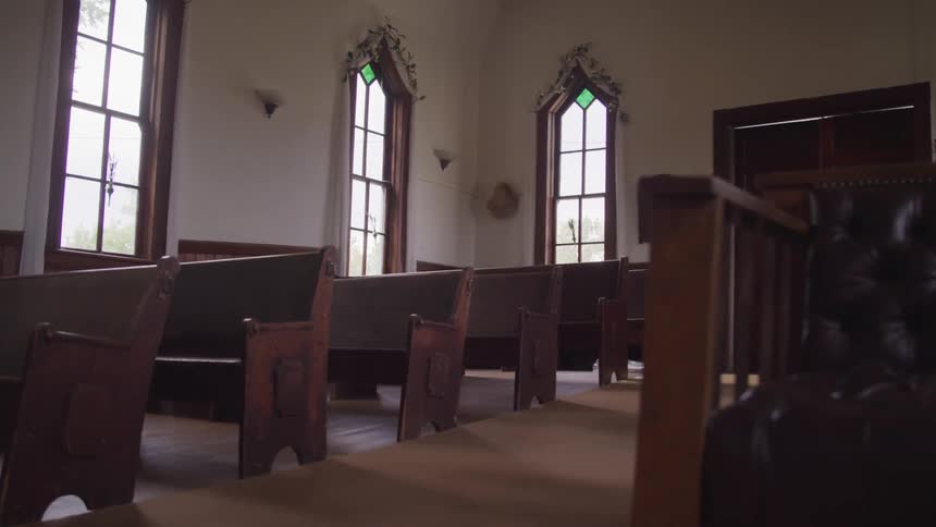Empty rows of benches fill a small church
