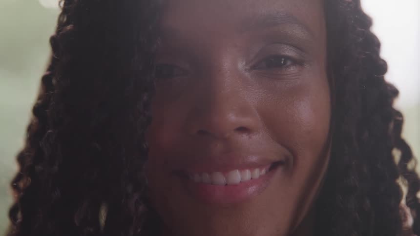 Curly hair black bride opens her eyes and smiles indoors