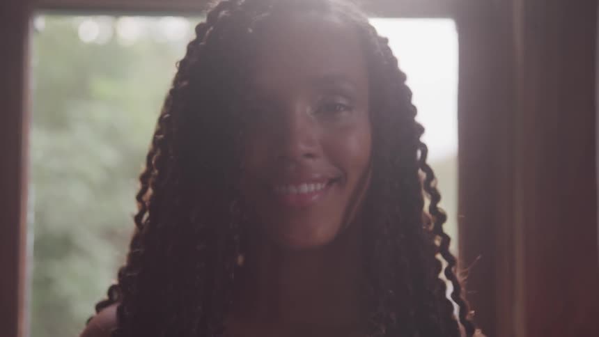 A portrait of a curly black woman smile