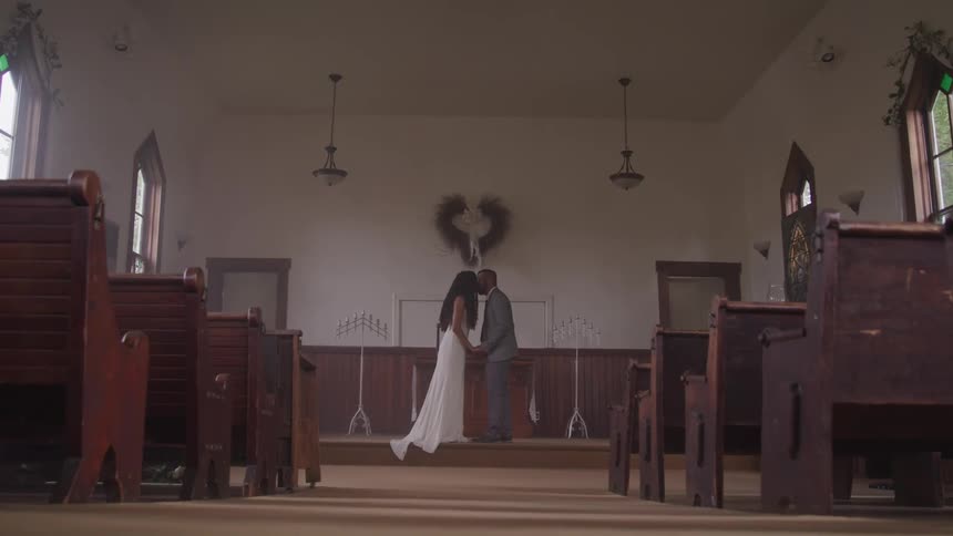 Newlyweds on church holding hands and kissing after ceremony