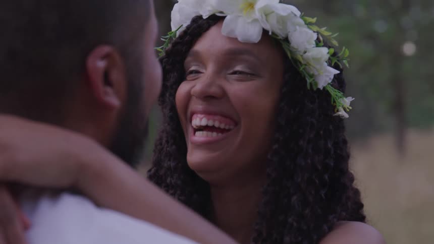 Groom and bride holding each other smile at one another during the wedding ceremony