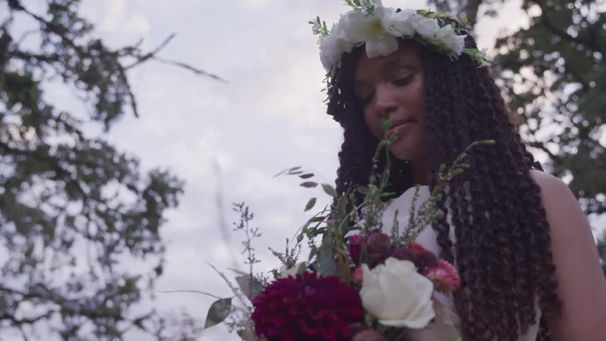 A woman standing holding a flower bouquet