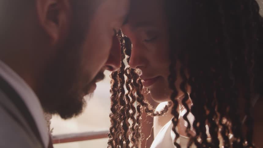 A man and woman touching foreheads praying with their eyes close