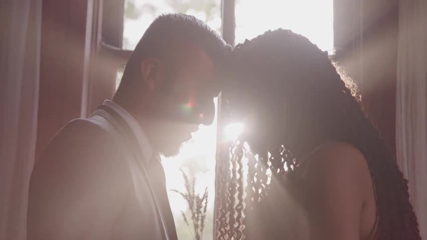 Man and woman embraced near a window