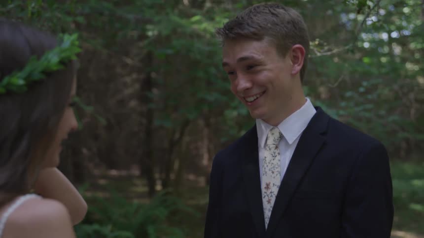 Groom and bride look at each other and smile during the wedding ceremony