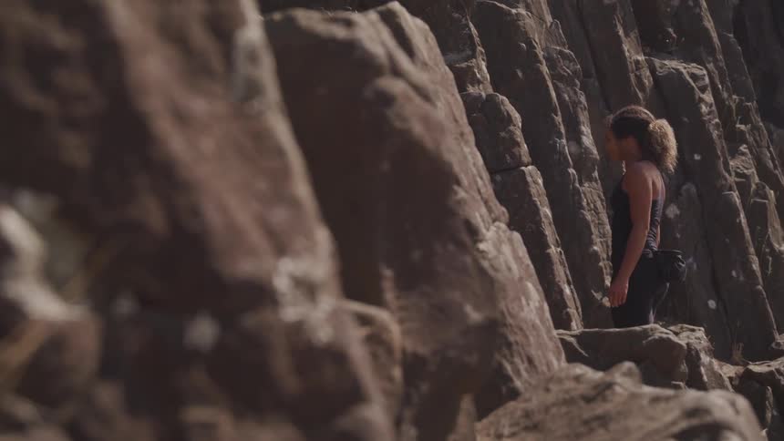 A woman prepares to climb a rock face