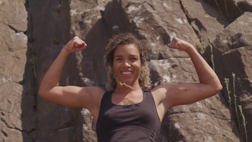A strong woman celebrate at the cliff