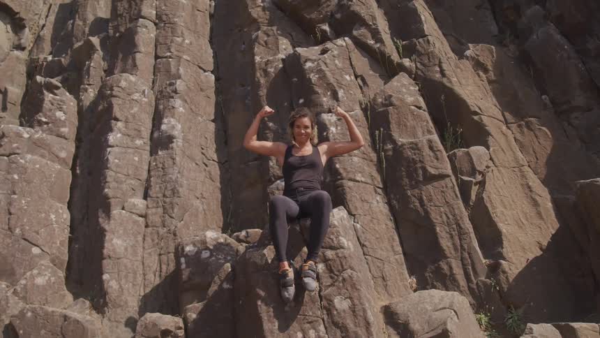 A woman sitting on top of a rock