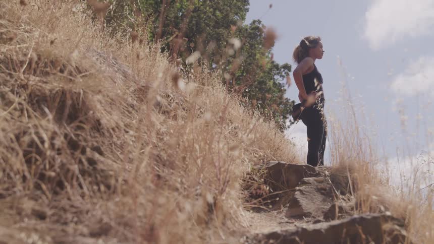 A black woman standing on the rock field
