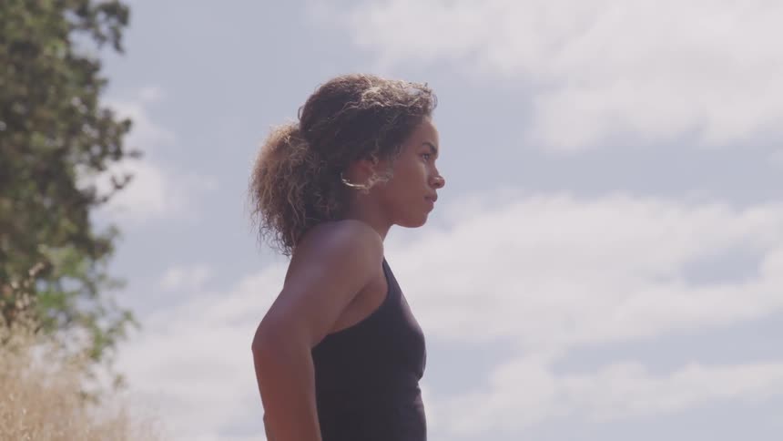 Black woman looks a head on the hill during the day