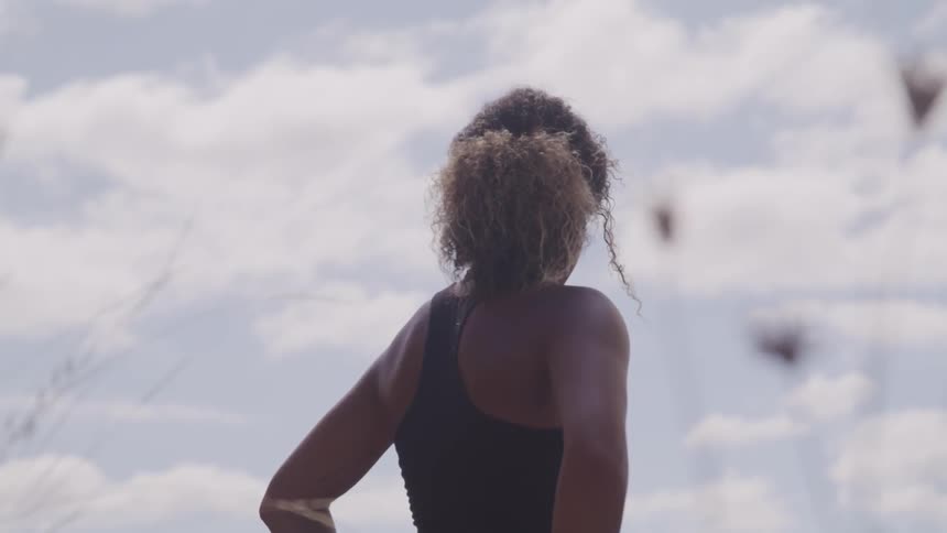 A black curly woman standing