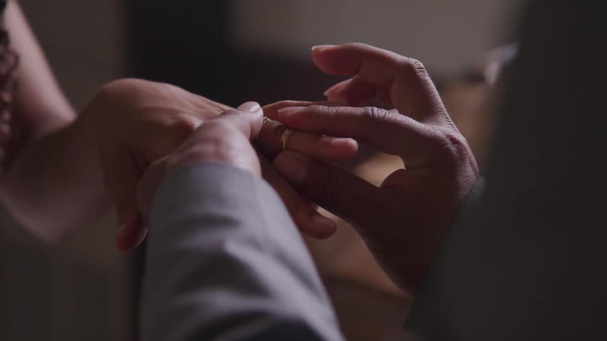 Man puts a ring on a womans finger