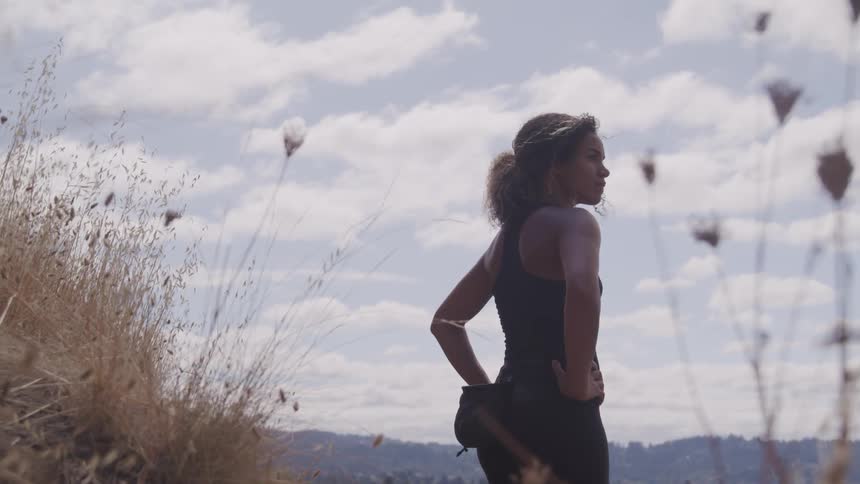 Black woman looks around on the hill during daylight