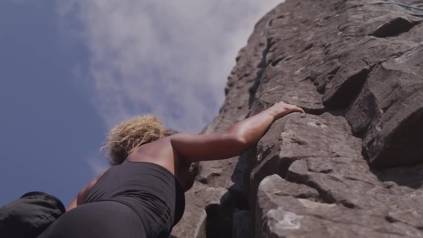 A woman rock climbing a cliff