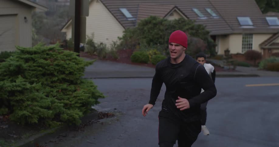 Two men running a race up a suburban road