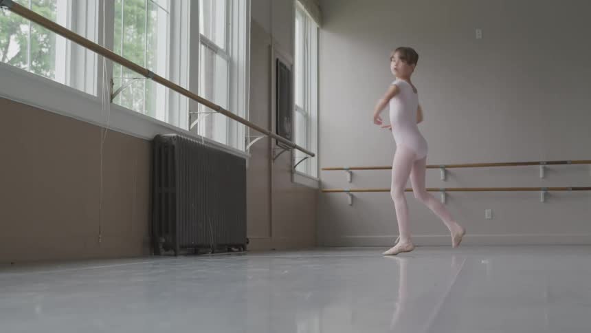 Little ballerina dances in the ballet studio