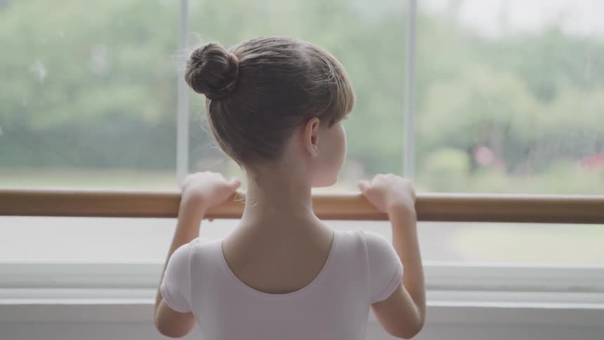 A child ballerina at the glass window