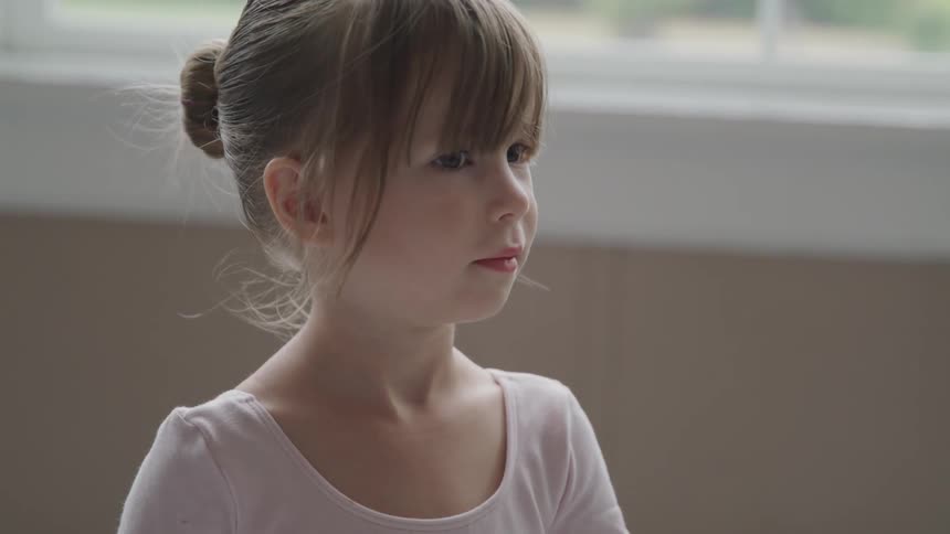 Little ballerina stands before performing in the ballet studio