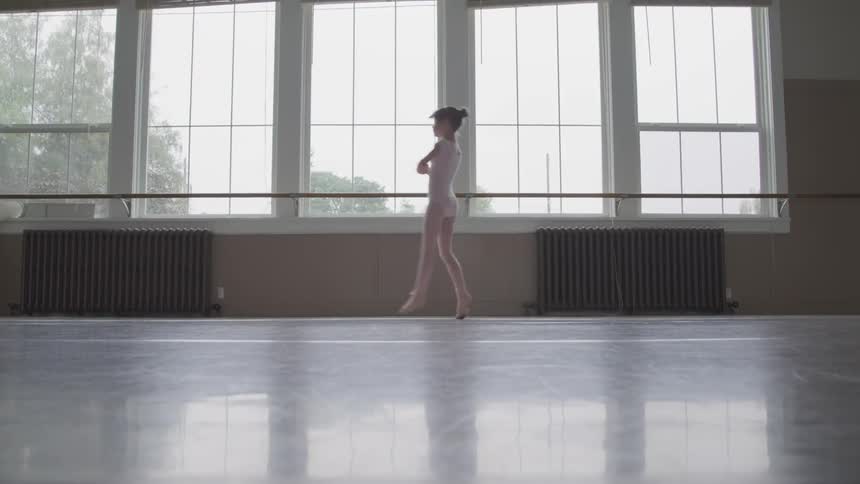 A child is doing ballet in a room