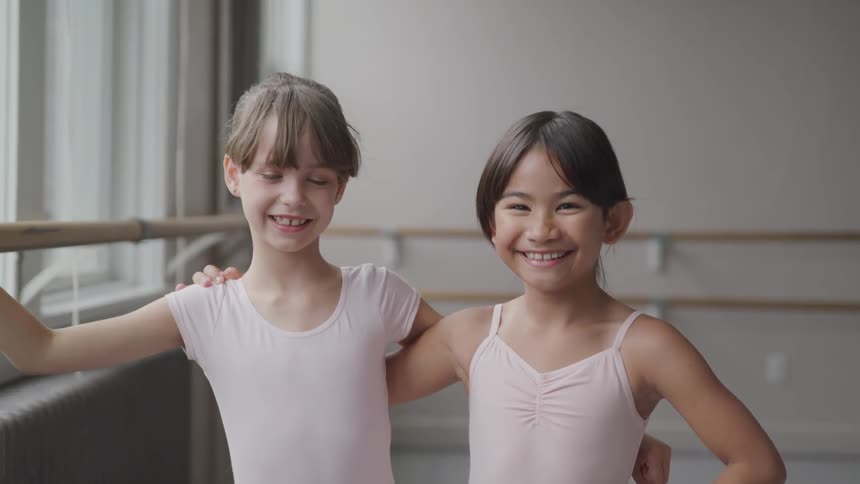 Ballerina girls standing on dance studio smiling at camera