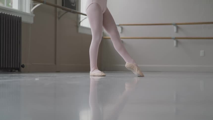 Ballerina legs jumping and twirling in a studio