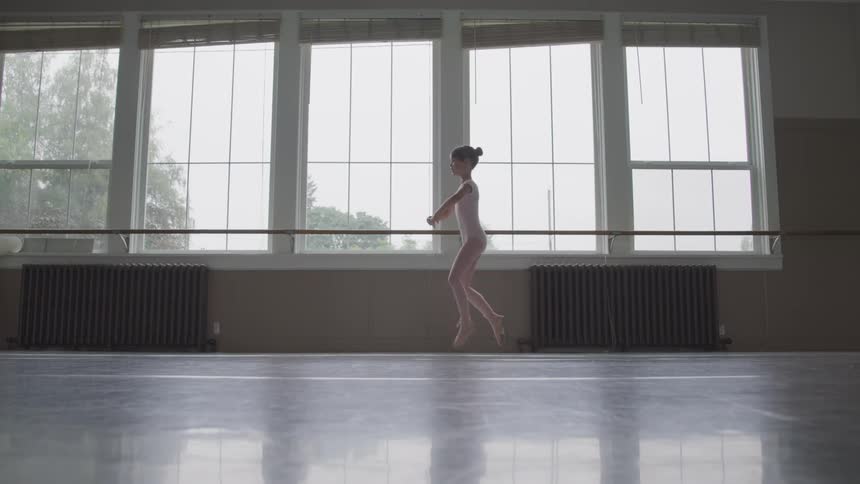 Little ballerina performs ballet in the ballet studio