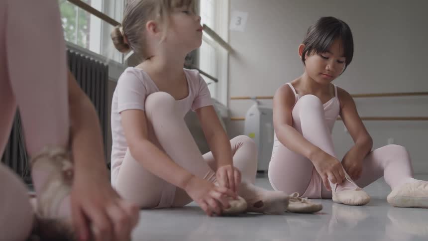 2 girl put their ballet shoes